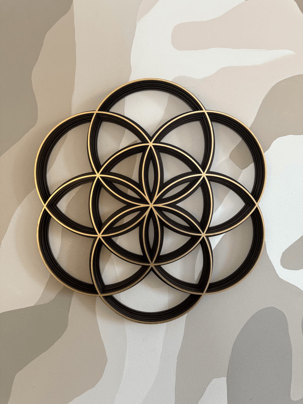 Decorative wall art of the Seed of Life on a neutral camouflage background